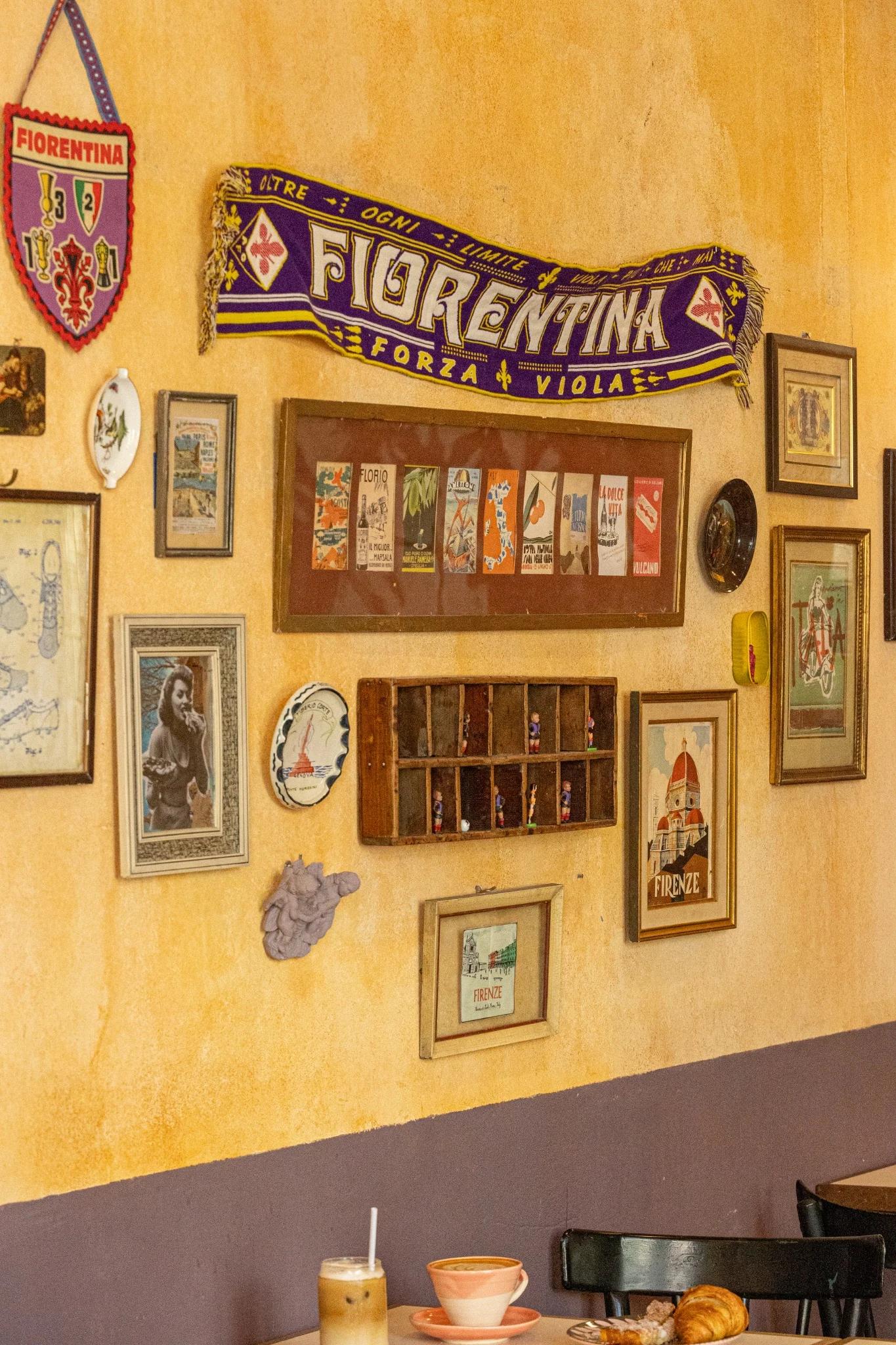 Cuadros italianos y una bufanda violeta de Fiorentina en nuestro local