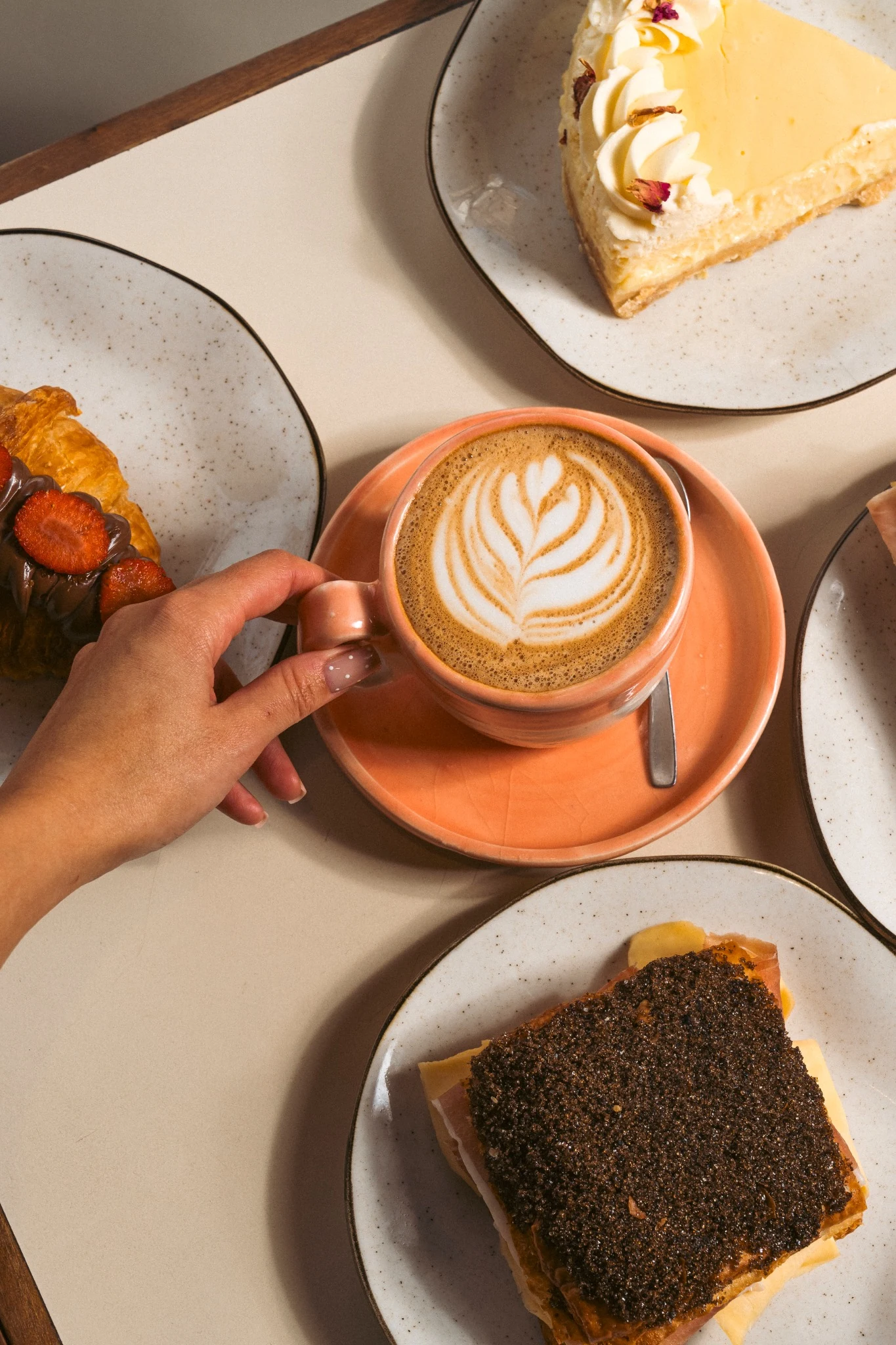 Tortita negra rellena y café con latte art en una mesa de Fiorentina